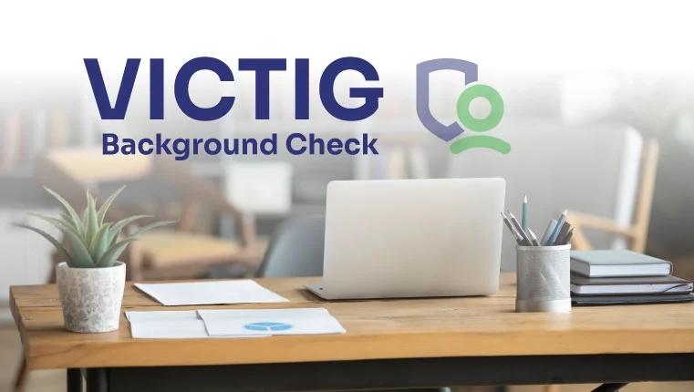 laptop laying on the table near victig background check