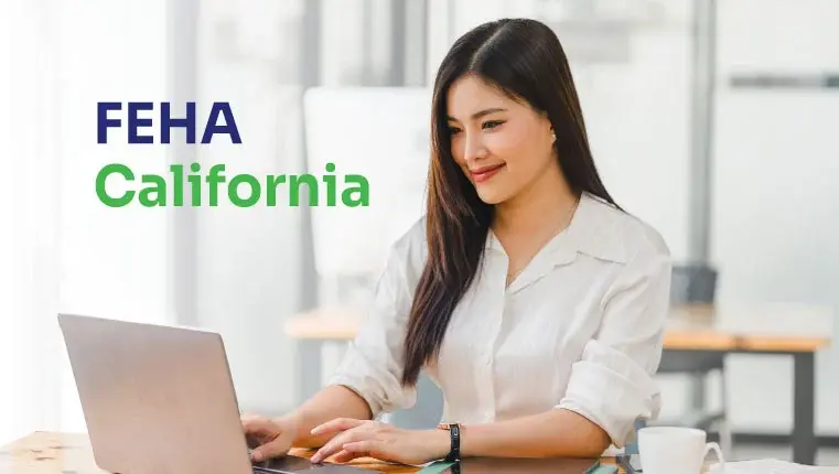 asian woman in a white shirt working behind her laptop