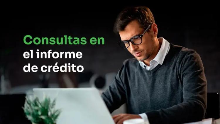 hombre sentado detrás de la computadora portátil tratando de eliminar las consultas en el informe de crédito