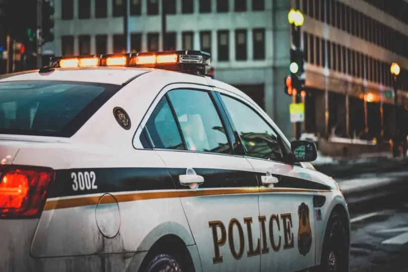 coche de policía parado en una intersección investigando un robo de identidad