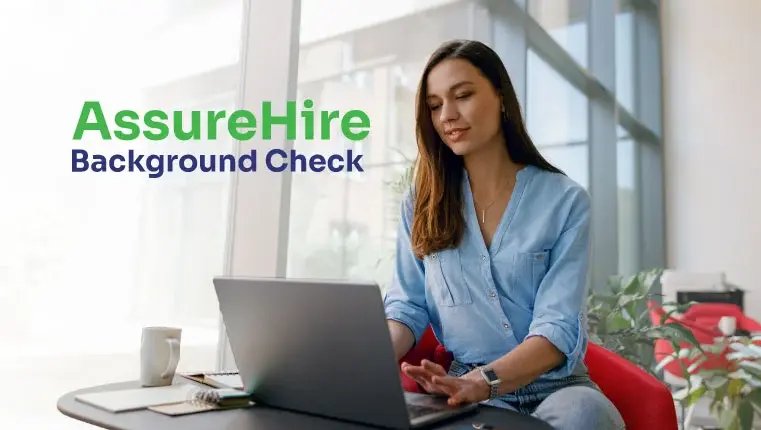AssureHire Background Check woman sitting in the red chair looking at her laptop
