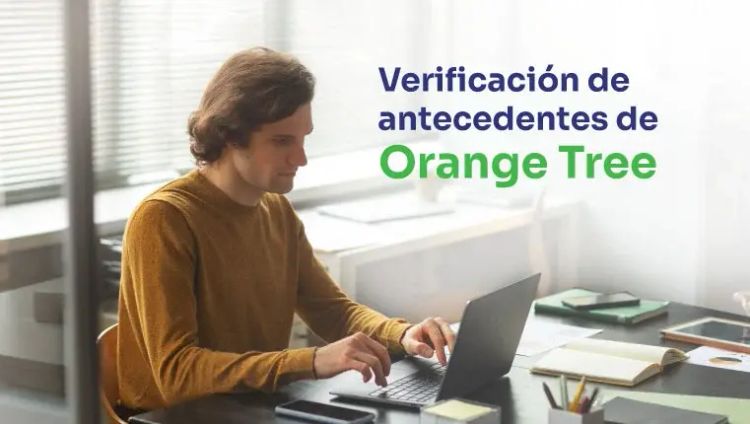 hombre vestido con un jersey marrón sentado detrás del portátil
