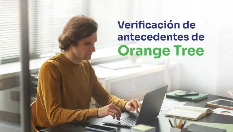 hombre vestido con un jersey marrón sentado detrás del portátil