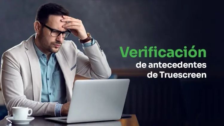 verificación de antecedentes de truescreen Hombre sosteniendo su cabeza sentado cerca de una computadora portátil