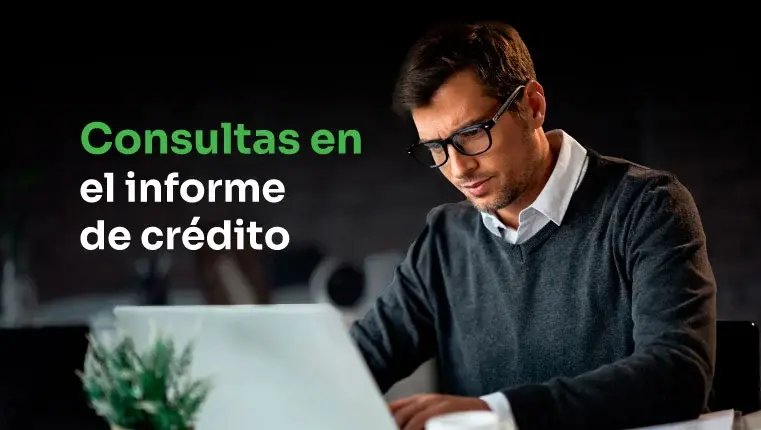 hombre sentado detrás de la computadora portátil tratando de eliminar las consultas en el informe de crédito